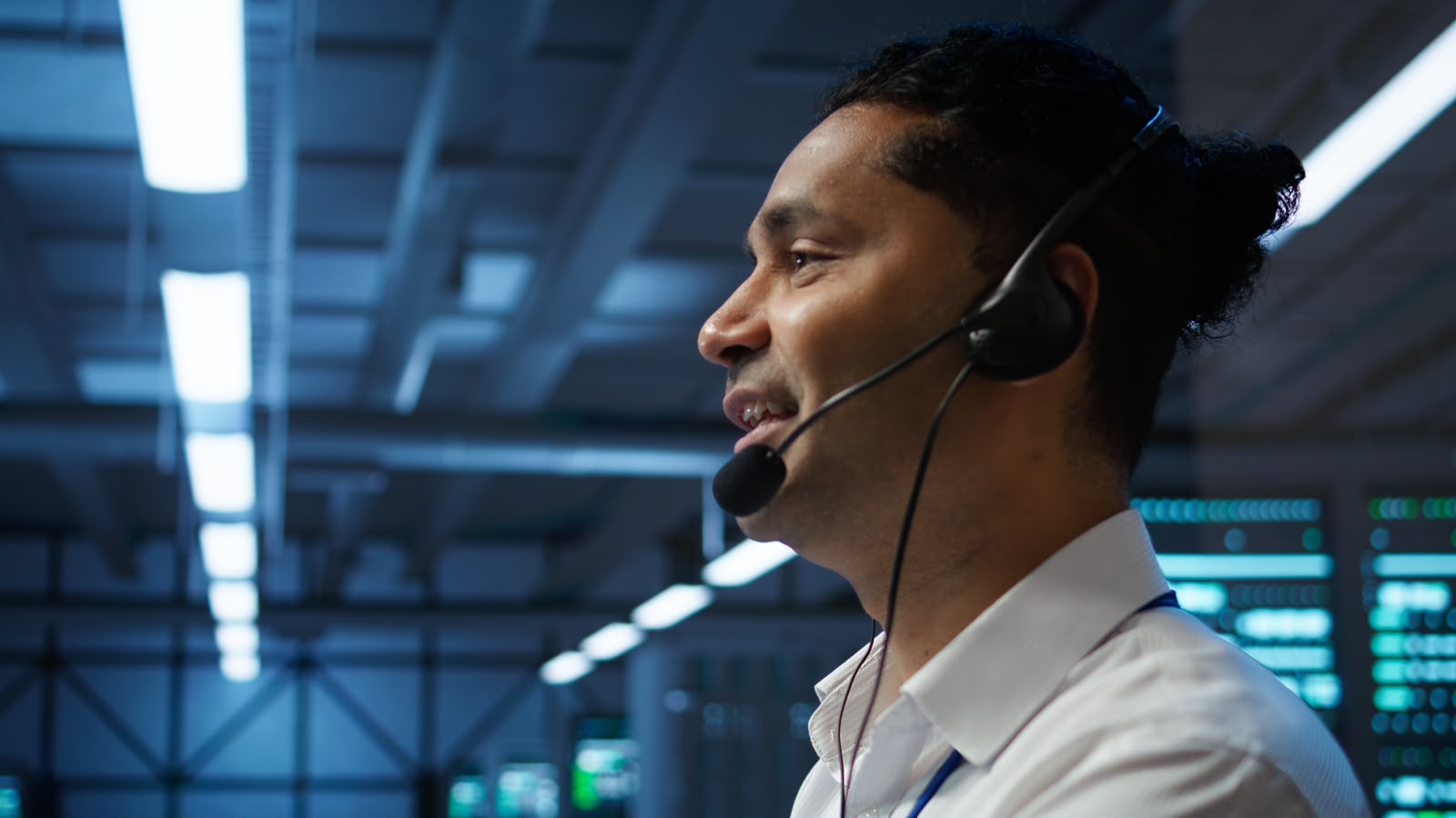 Operations specialist wearing a headset in a modern technical support environment